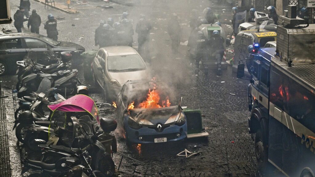 Sogar ein Polizeiauto geriet bei den Krawallen in Brand (© ANSA/SID/CIRO FUSCO)